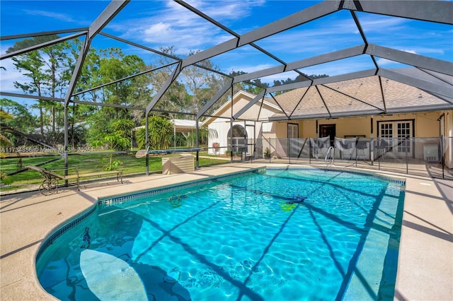 view of swimming pool featuring a lanai, a patio area, and french doors