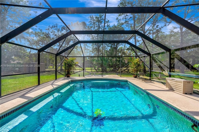 view of swimming pool featuring glass enclosure and a patio area