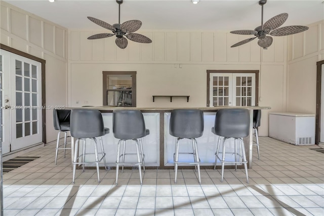 view of patio featuring a bar, french doors, and ceiling fan