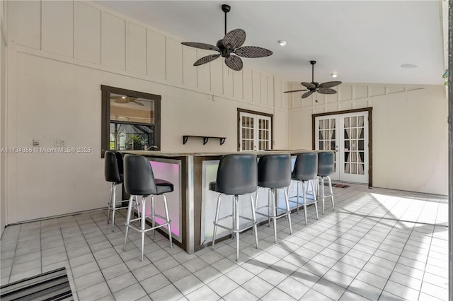 view of patio / terrace featuring a bar, ceiling fan, and french doors