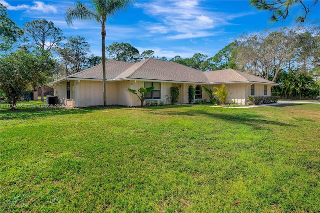 single story home featuring cooling unit and a front lawn