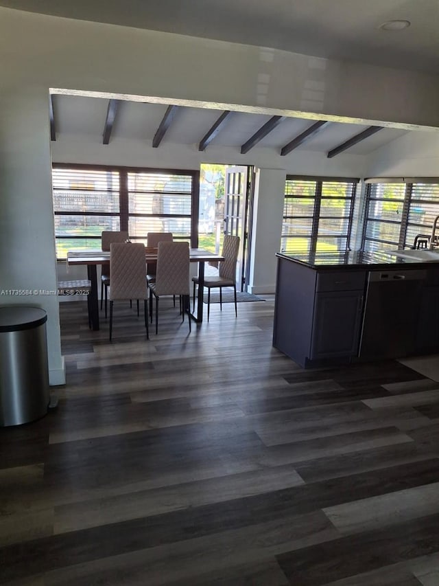 dining area with a healthy amount of sunlight, dark hardwood / wood-style flooring, and vaulted ceiling with beams