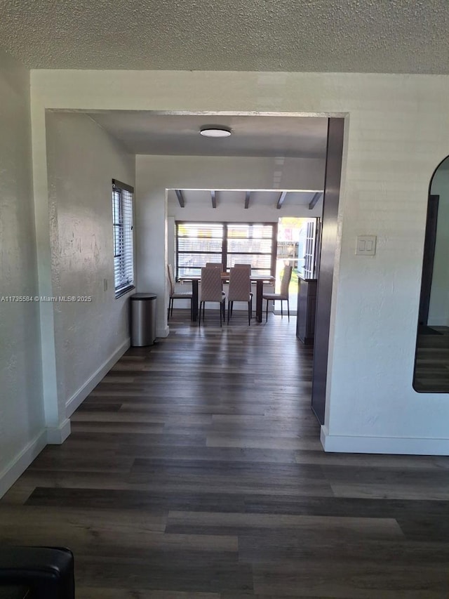 hallway featuring dark hardwood / wood-style floors and a textured ceiling