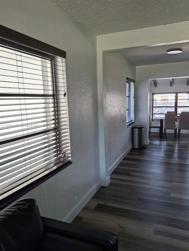 hall with dark hardwood / wood-style flooring and a textured ceiling