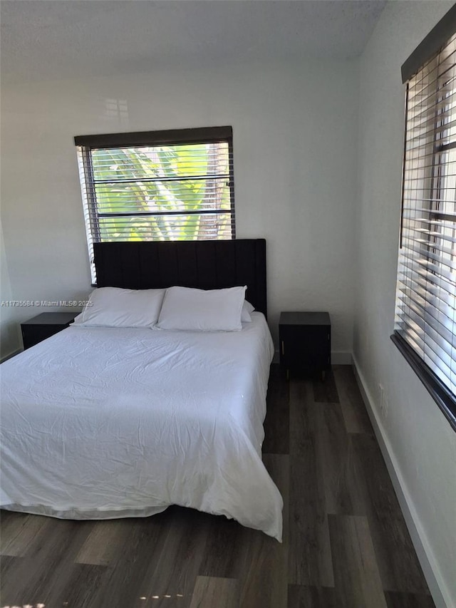 bedroom with dark hardwood / wood-style floors