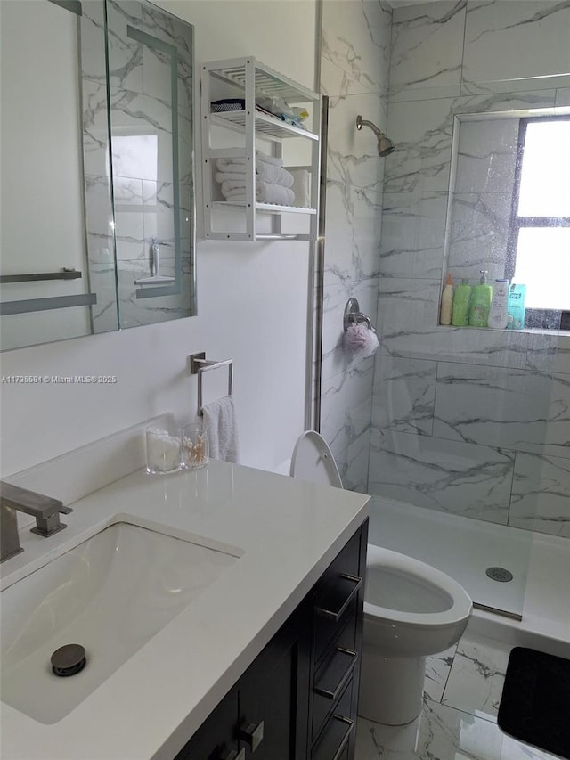 bathroom featuring vanity, toilet, and tiled shower