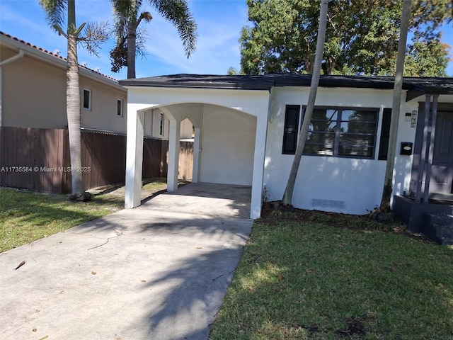 view of front of property featuring a carport and a front lawn