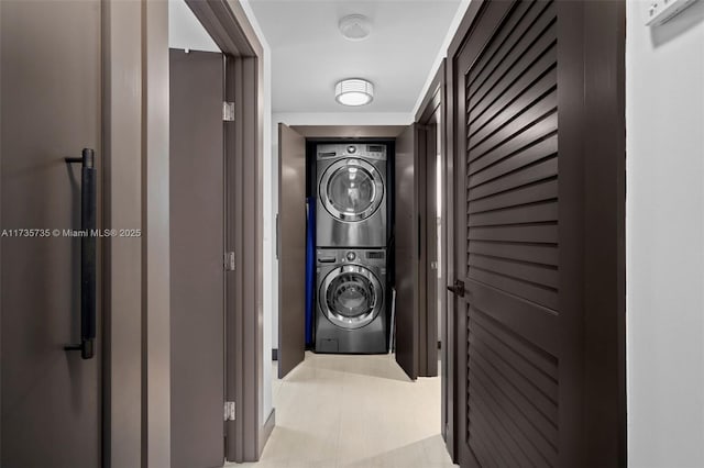 clothes washing area featuring stacked washer and clothes dryer