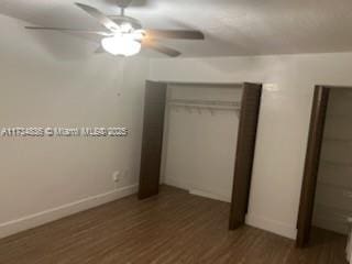 unfurnished bedroom featuring dark hardwood / wood-style floors, ceiling fan, and a closet