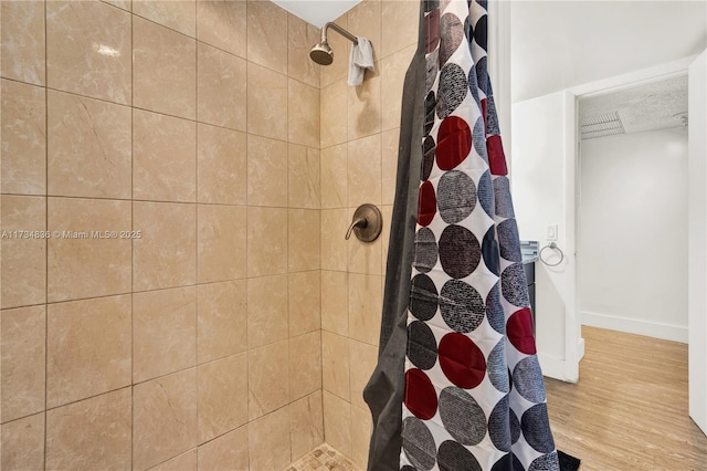 bathroom featuring hardwood / wood-style flooring and walk in shower