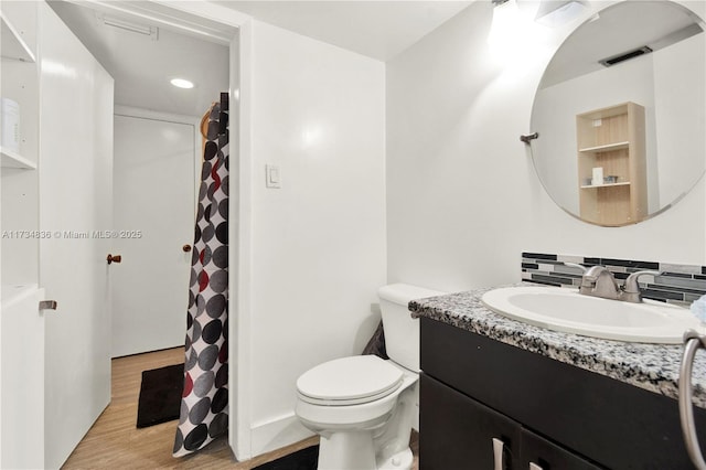 bathroom featuring vanity, tasteful backsplash, toilet, and hardwood / wood-style floors