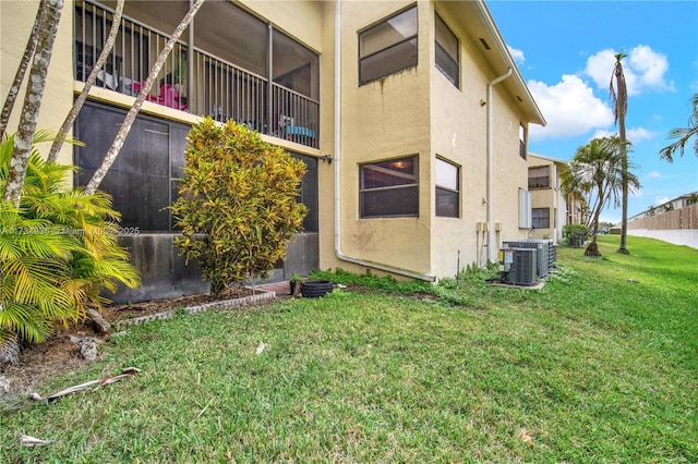 view of property exterior with central AC unit and a lawn