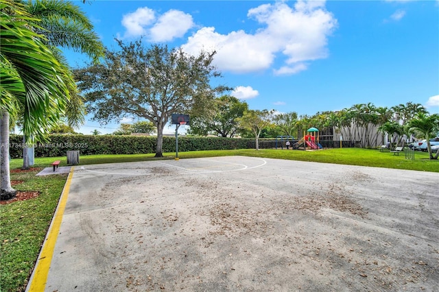 view of basketball court featuring a playground and a lawn