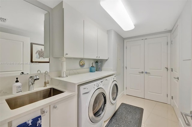 laundry room with cabinets, washing machine and dryer, sink, and light tile patterned floors