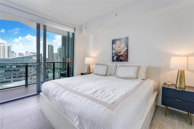 bedroom featuring floor to ceiling windows and light hardwood / wood-style flooring