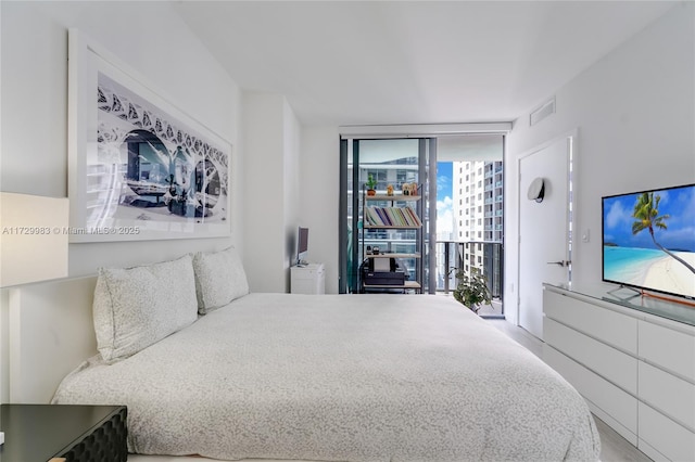 bedroom featuring expansive windows and access to outside