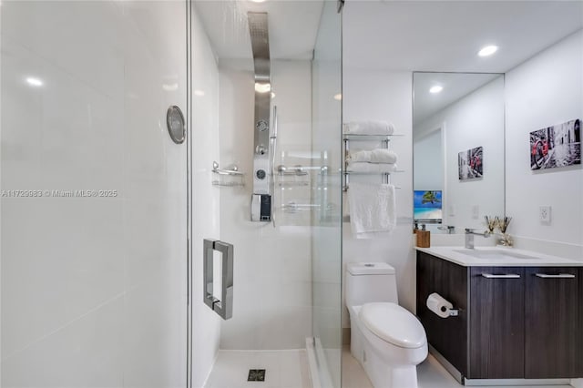 bathroom with toilet, vanity, and a shower with shower door