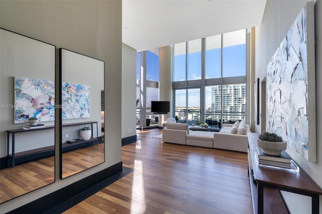 living room featuring expansive windows, a high ceiling, and hardwood / wood-style flooring