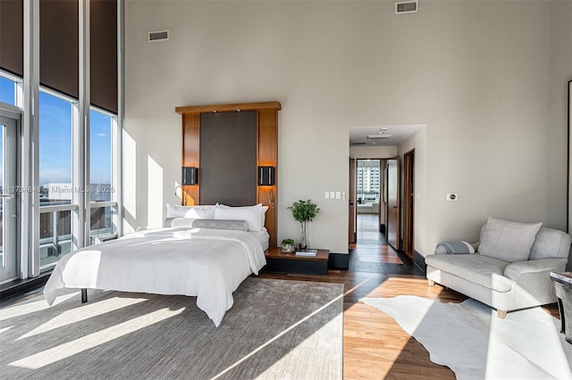 bedroom with dark wood-type flooring and a towering ceiling