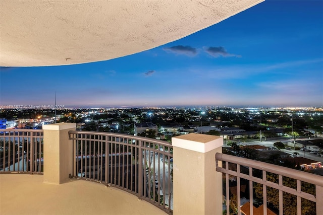 balcony at dusk with a water view and a beach view