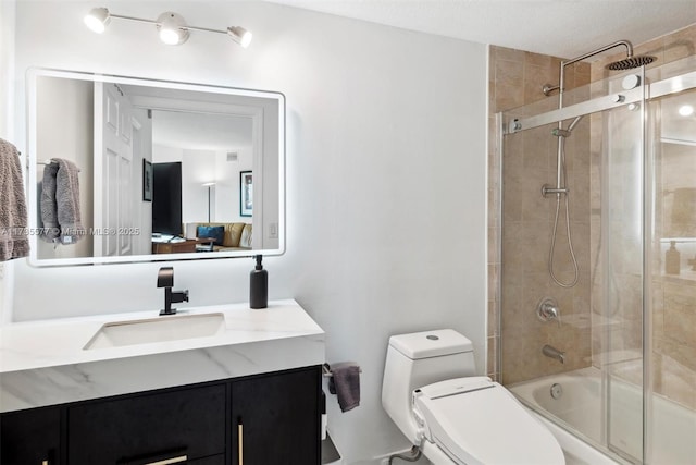 full bathroom featuring vanity, bath / shower combo with glass door, and toilet