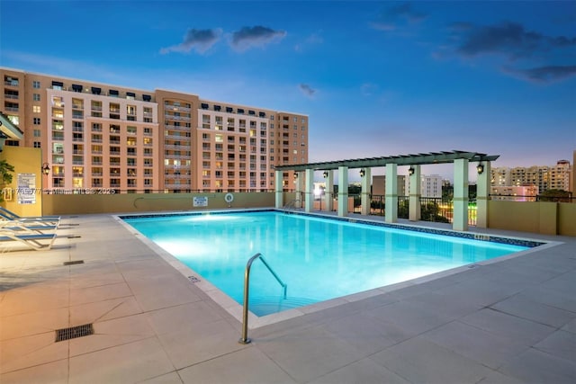 pool at dusk with a patio