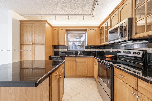 kitchen with sink, light tile patterned flooring, a textured ceiling, and appliances with stainless steel finishes