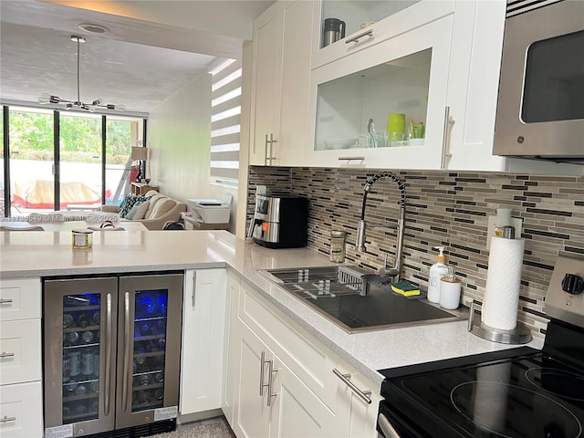 kitchen with wine cooler, tasteful backsplash, stainless steel appliances, and white cabinets