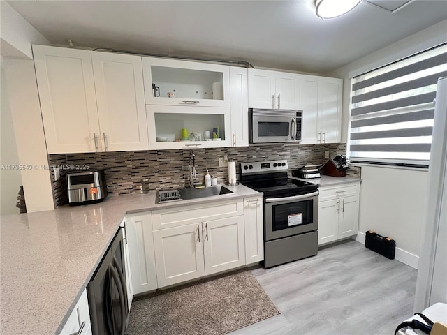 kitchen with stainless steel appliances, sink, and white cabinets