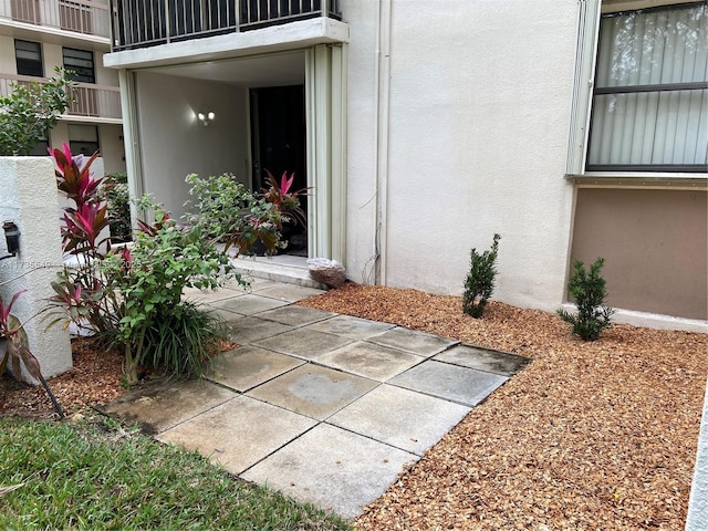 view of exterior entry with a patio and a balcony