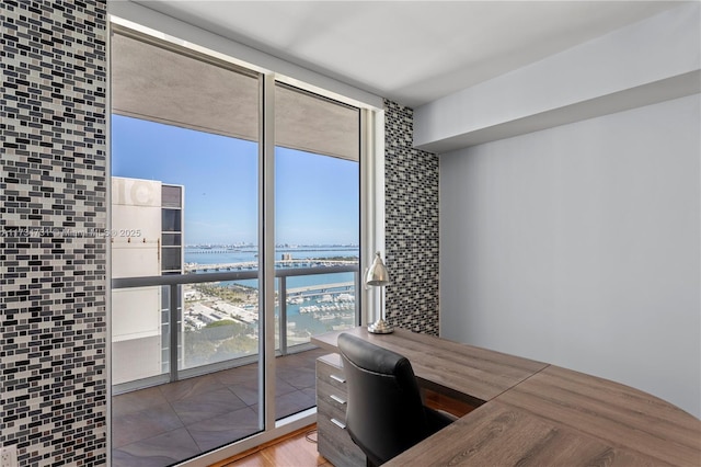 home office featuring a water view and a wall of windows