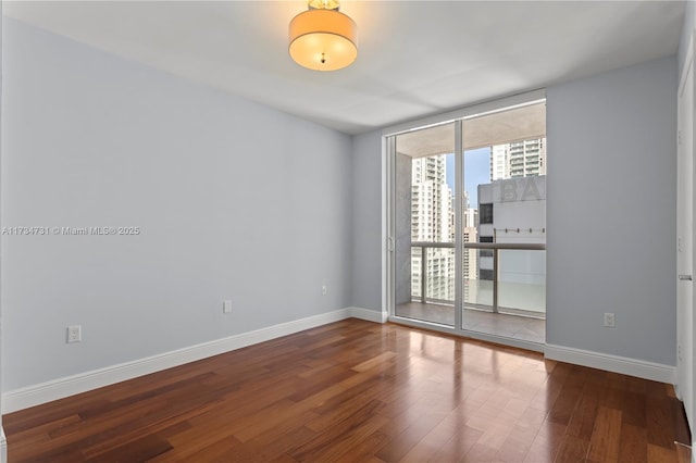 unfurnished room with hardwood / wood-style flooring and floor to ceiling windows