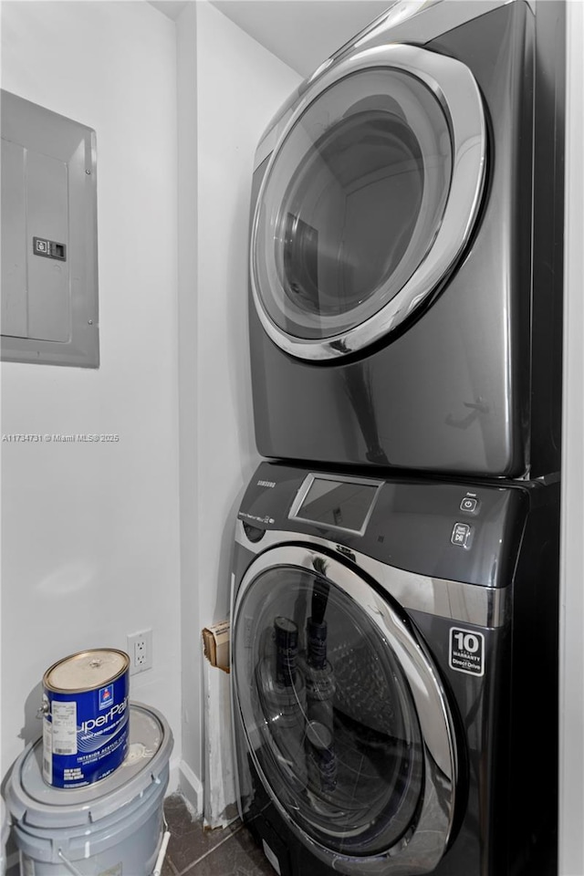 laundry room with stacked washer and clothes dryer and electric panel