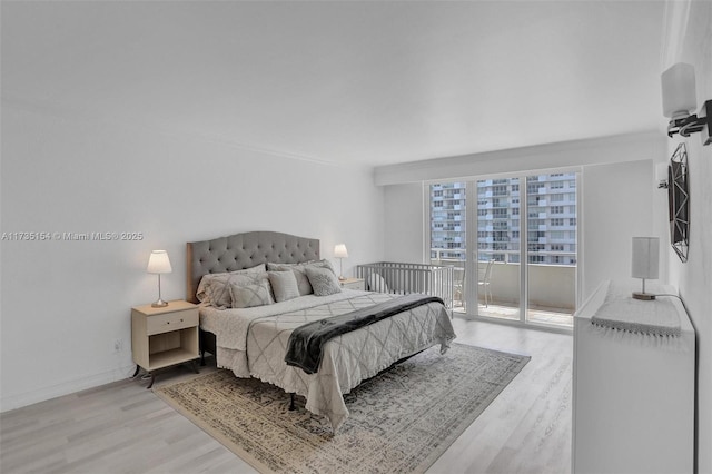 bedroom with access to outside and light wood-type flooring