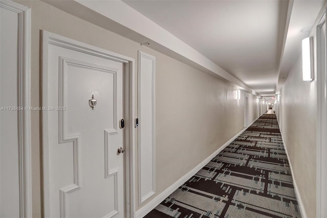 hallway with dark colored carpet