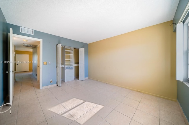 unfurnished bedroom with light tile patterned floors and a closet