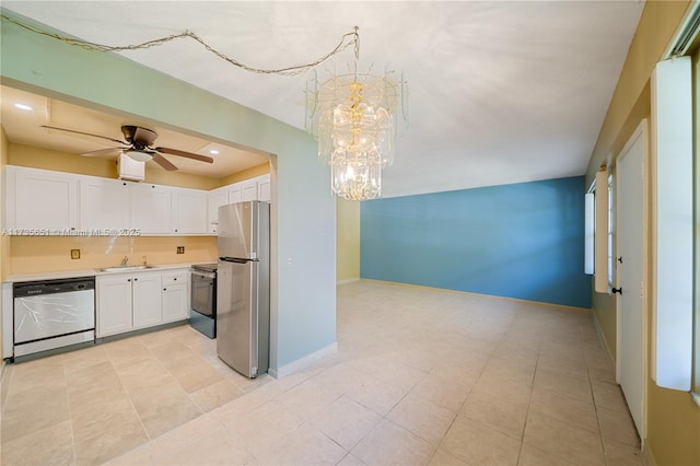 kitchen featuring sink, appliances with stainless steel finishes, pendant lighting, ceiling fan with notable chandelier, and white cabinets