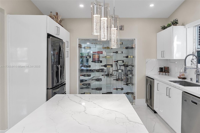 kitchen with sink, white cabinetry, refrigerator, stainless steel dishwasher, and pendant lighting