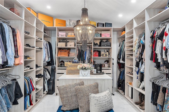 spacious closet with an inviting chandelier