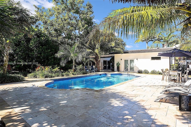 view of swimming pool with french doors and a patio area