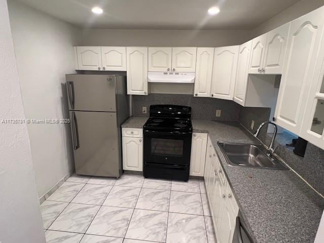 kitchen with stainless steel refrigerator, sink, backsplash, white cabinets, and black range with electric cooktop