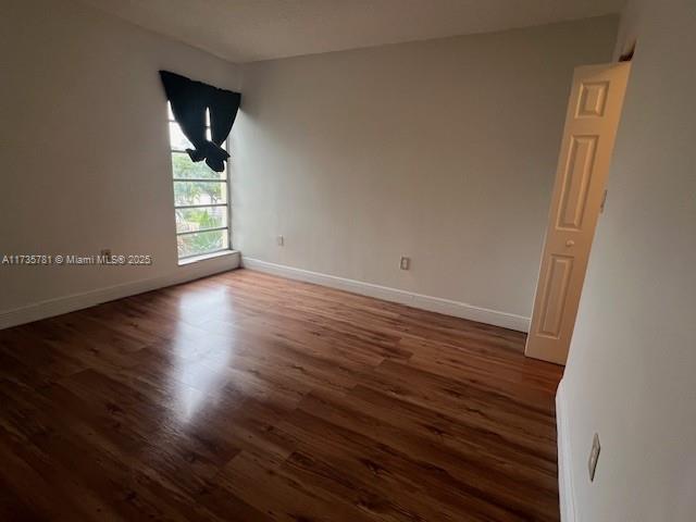 spare room featuring dark wood-type flooring