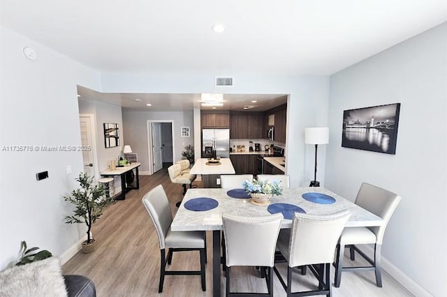 dining room with recessed lighting, visible vents, baseboards, and light wood finished floors