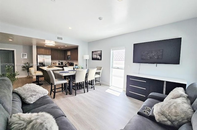 living area with light wood-style flooring, recessed lighting, baseboards, and visible vents