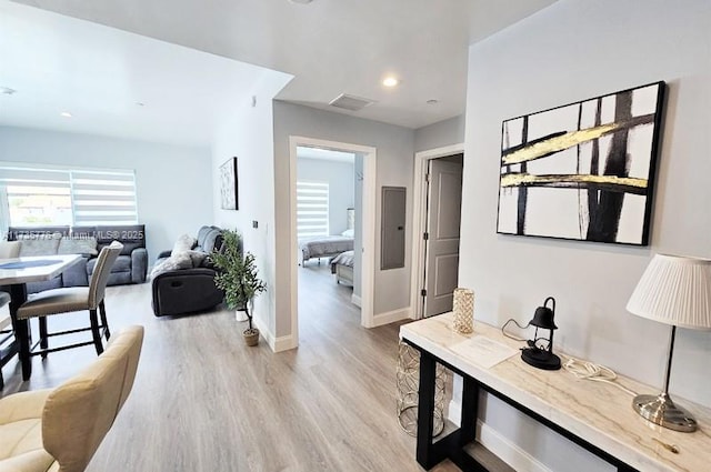 hallway featuring light wood-style flooring, recessed lighting, visible vents, and baseboards