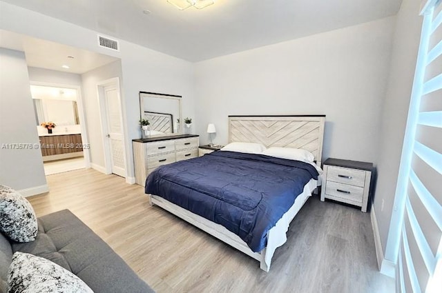 bedroom featuring visible vents, ensuite bathroom, baseboards, and wood finished floors