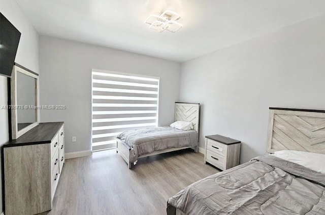 bedroom featuring baseboards and light wood finished floors