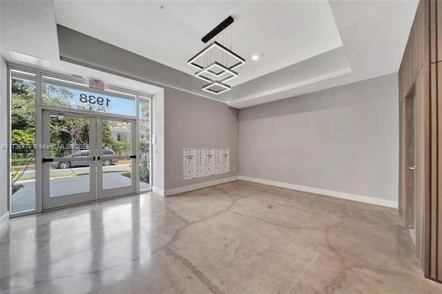 spare room with french doors, concrete floors, and baseboards