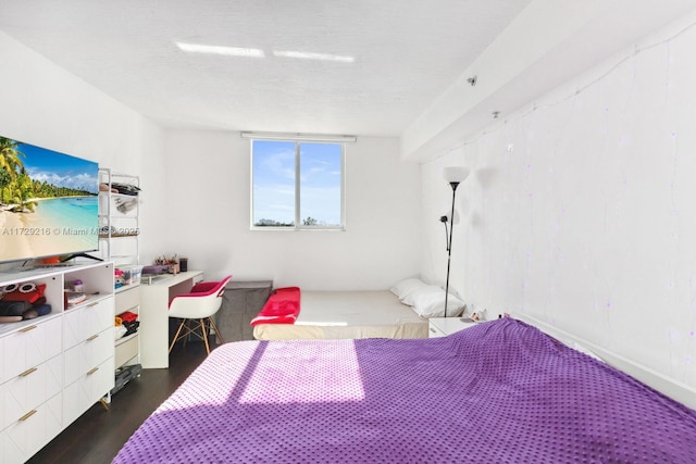 bedroom featuring dark wood-type flooring and a textured ceiling