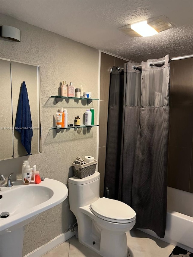 full bathroom with sink, shower / bath combo, tile patterned flooring, a textured ceiling, and toilet